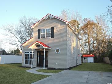 Two-story house with red roof and landscaped lawn at 9215 Greeneedle Pl., Murrells Inlet, SC 29576