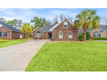 Charming brick home featuring a well-manicured lawn and palm trees lining the driveway, enhancing curb appeal at 113 Preservation Dr., Myrtle Beach, SC 29572