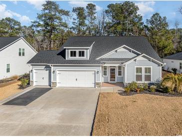 Two-story house with gray siding, three-car garage, and landscaped yard at 146 Caroline Ct., Murrells Inlet, SC 29576