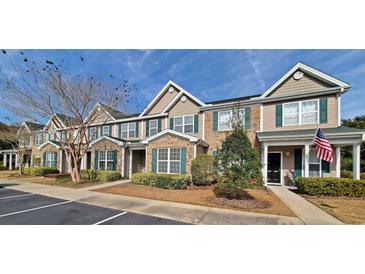 Two-story townhome with brick and siding exterior, landscaping, and American flag at 155 E Chenoa Dr. # E, Murrells Inlet, SC 29576