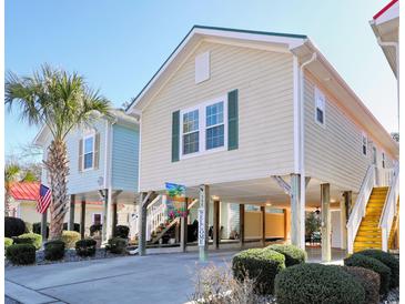 Charming elevated home features a spacious covered area, stairs, landscaping, and a welcoming atmosphere at 502 Castellar Ln., Little River, SC 29566