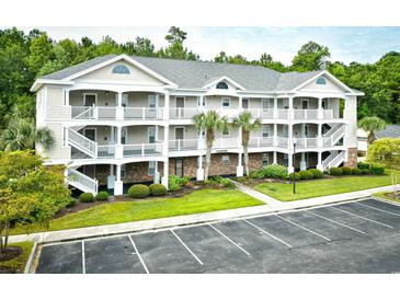 Three-story building with multiple units, ample parking, and landscaping at 6015 Catalina Dr. # 431, North Myrtle Beach, SC 29582