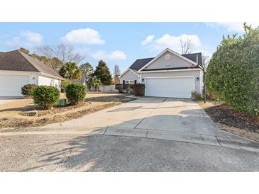 House exterior featuring a gray vinyl-sided home with a two-car garage and a well-manicured lawn at 1209 Peyton Ct., Myrtle Beach, SC 29588