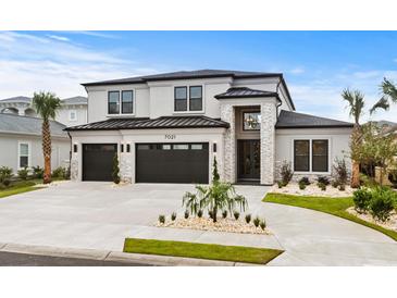 Two-story house with a three-car garage, stone accents, and landscaping at 215 82Nd Ave. N, Myrtle Beach, SC 29572