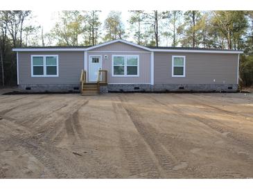 Tan mobile home with wood deck and landscaping at 2901 N Nichols Hwy., Nichols, SC 29581