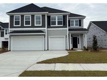 Two story home with gray siding, dark shutters, a two car garage, and concrete driveway at 4023 Bucolic Loop, Myrtle Beach, SC 29588