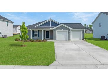 Charming single-story home showcasing a well-manicured lawn and a two-car garage at 57 Cape Point Dr., Conway, SC 29527