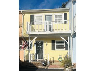 Charming yellow two-story home with balcony and American flag at 3866 Highway 17 Business # C-3, Murrells Inlet, SC 29576
