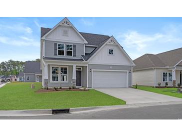 Charming two-story home with gray siding, a well-manicured lawn, and an attached two-car garage at 1212 Nw Calabash Station Blvd., Calabash, NC 28467