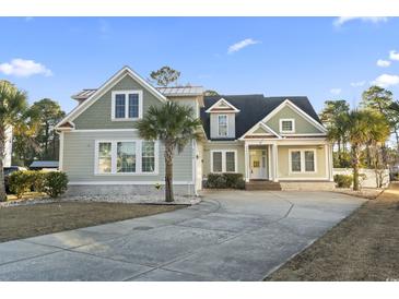 Charming home featuring a well-manicured lawn, mature landscaping, and inviting front porch at 2113 Clematis Ct., Myrtle Beach, SC 29579