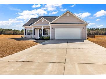 Beige house with a two-car garage and a spacious front yard at 3604 Pasture Rd., Aynor, SC 29511