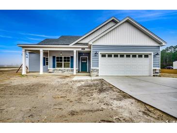 Newly constructed home with gray siding, stone accents, and a two-car garage at 4983 Dupont Rd., Conway, SC 29526