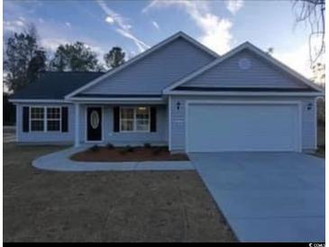 Newly built home with gray siding, two-car garage, and landscaping at Tbd10 Casey Dr., Green Sea, SC 29545