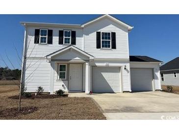 Charming two-story home with white siding and a spacious three car garage, perfect for a growing Gathering at 1508 Clubstone Dr., Conway, SC 29526