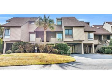 Attractive condo building with a spacious driveway and lush landscaping at 203 Heron Marsh Dr. # 78, Pawleys Island, SC 29585