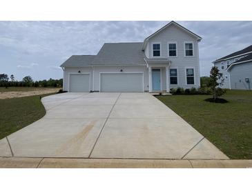 Charming two-story home featuring a two-car garage, light blue door, and a concrete driveway leading to a spacious front yard at 251 Letha Dr, Longs, SC 29568