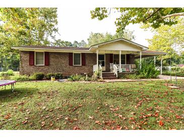 Brick ranch house with covered porch, landscaping, and large yard at 3657 Highway 472, Conway, SC 29526