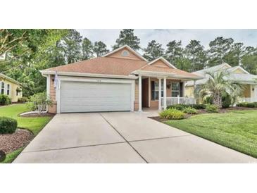 Charming one-story home with a manicured lawn and attached two-car garage with neutral colored exterior at 414 Grand Cypress Way, Murrells Inlet, SC 29576