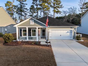 Charming single-story home with well-maintained landscaping, two-car garage, and inviting front porch at 440 Craigflower Ct., Longs, SC 29568