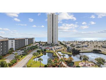 Beautiful exterior view of a high-rise building with landscaped grounds and a serene pond at 5905 S Kings Hwy. # 312-C, Myrtle Beach, SC 29575