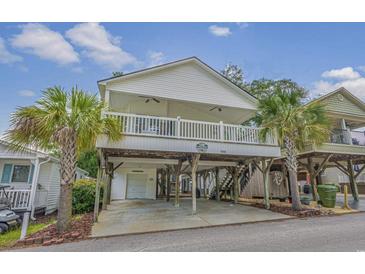 Elevated beach house with wrap-around porch and parking underneath at 6001-1830A S Kings Highway, Myrtle Beach, SC 29575