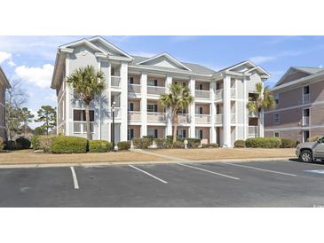 Exterior view of a condo complex featuring balconies, palm trees and convenient parking spaces at 627 Waterway Village Dr. # 8-I, Myrtle Beach, SC 29579