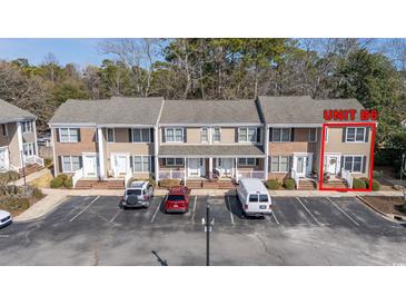 A charming townhouse showcases neat landscaping and designated parking spaces for convenient access at 6702 Jefferson Pl. # B6, Myrtle Beach, SC 29572