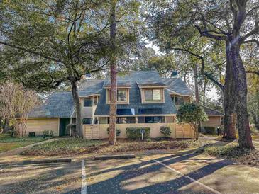 Charming condo showcasing the exterior facade with mature landscaping and assigned parking at 109 Westhill Circle # 3-C, Myrtle Beach, SC 29572