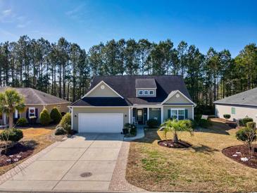 Charming single Gathering home with a well manicured front yard and an attached two car garage at 128 Belclare Way, Longs, SC 29568