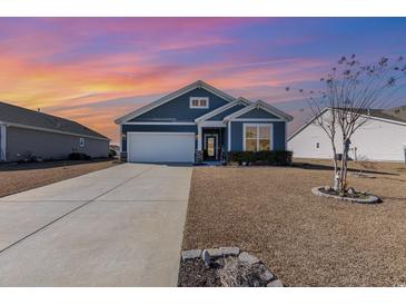 Charming single-story home with blue siding, a well-manicured lawn, and a two-car garage at 1377 Tessera Way, Myrtle Beach, SC 29579