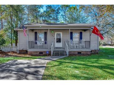 Gray house with a porch, rocking chairs, and American flags at 1500 Docksider Ct., Surfside Beach, SC 29575