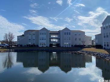 Exterior of condo building overlooking a pond with blue skies at 2265 Huntington Dr. # A, Surfside Beach, SC 29575