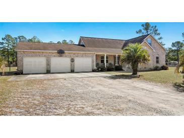 Charming brick home featuring an attached three-car garage and a well-manicured front yard at 2531 Smiley Ln., Conway, SC 29526