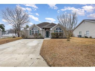 Charming single-story home with a brick facade, green shutters, and a well-manicured lawn at 3931 East Glades Dr., Myrtle Beach, SC 29588