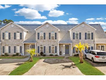 Three-unit townhome building with light brick exterior and landscaping at 3983 Tybre Downs Circle # 3983, Little River, SC 29566