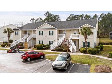 Condominium building with tan siding, green shutters, white railings, and well-maintained landscaping at 4933 Crab Pond Ct. # 202, Myrtle Beach, SC 29579