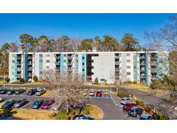 Apartment building featuring multiple stories, parking, and colorful blue and white exterior at 5001 Little River Rd. # W-214, Myrtle Beach, SC 29577