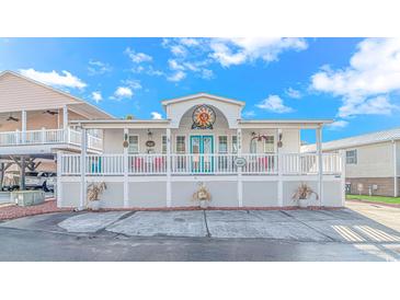 Charming coastal cottage with white exterior, teal accents, and a spacious porch at 6001-6012 S Kings Hwy., Myrtle Beach, SC 29575