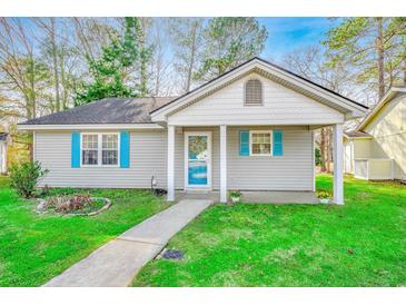 Charming single-story home featuring blue shutters, a well-manicured lawn, and a welcoming entrance at 6644 E Sweetbriar Trail, Myrtle Beach, SC 29588