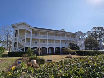 Two-story building with multiple units and a well-maintained lawn at 703 Riverwalk Dr. # 103, Myrtle Beach, SC 29579