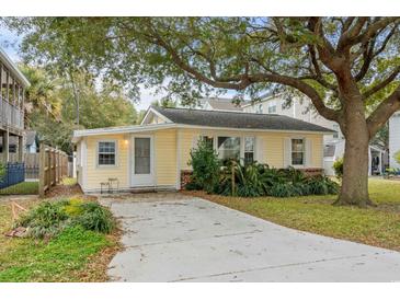 Charming single-story home with yellow siding, mature trees, and well-maintained landscaping at 913 S Dogwood Dr. S, Surfside Beach, SC 29575