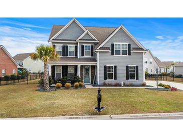 Charming two-story home with gray siding, black shutters, a palm tree, and a well-manicured lawn at 931 Desert Wheatgrass Dr., Myrtle Beach, SC 29579