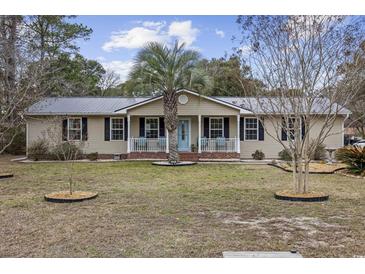 Charming ranch home with a metal roof, palm tree, and covered front porch at 1031 Madge Ct., Conway, SC 29526