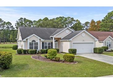 Charming one-story home featuring a well-manicured lawn, mature trees, and an attached two-car garage at 5215 Southern Trail, Myrtle Beach, SC 29579