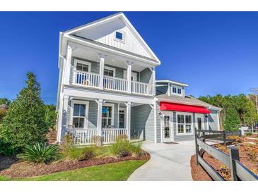 Charming two-story home with a double porch, manicured landscaping, and a bright red awning at 2505 Brescia St., Myrtle Beach, SC 29579
