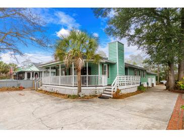 Charming green home with a white picket fence and a lush palm tree in the front yard at 5520 N Kings Hwy., Myrtle Beach, SC 29577