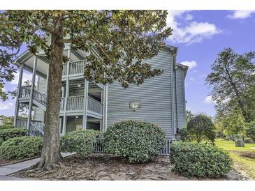 Charming condo exterior with wooden staircases, lush landscaping and mature trees, creating a serene outdoor setting at 5905 South Kings Hwy. # 4309, Myrtle Beach, SC 29575