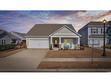 Charming single-Gathering home featuring a cozy front porch, well-manicured lawn, and an attached garage at 834 Summer Starling Pl., Myrtle Beach, SC 29577