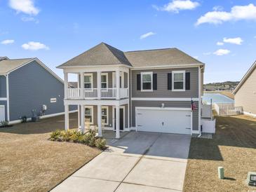 Charming two-story home boasts a double front porch and an attached two-car garage with a wide driveway at 1047 Harbison Circle, Myrtle Beach, SC 29579
