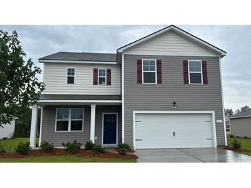 Charming two-story home features a two-car garage, neutral siding, and a well-maintained lawn at 149 Leyland Cypress Dr, Conway, SC 29527
